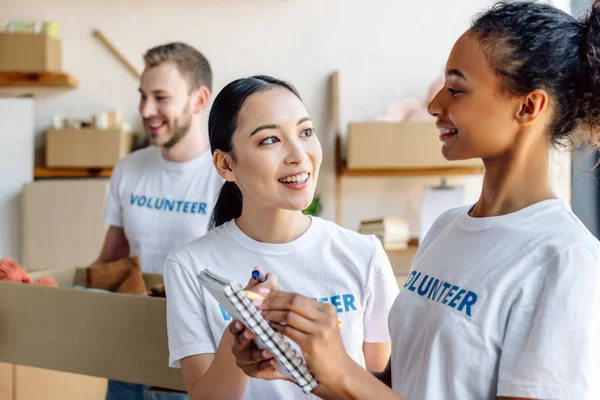 Selective Focus Pretty Multicultural Volunteers Talking While Holding Notebook — Stock Photo, Image