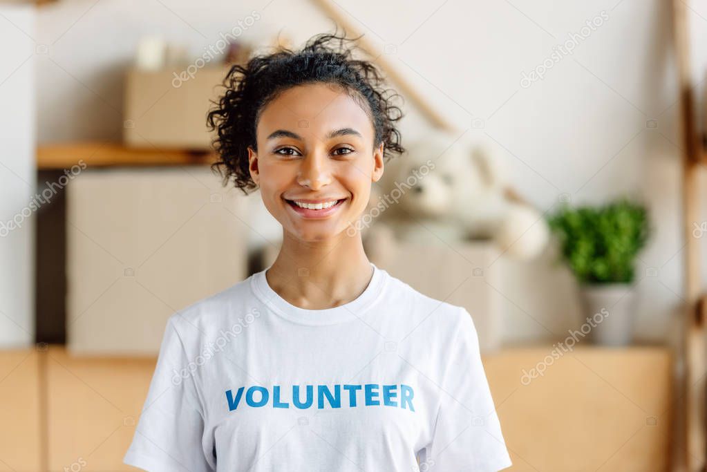 beautiful african american volunteer smiling and looking at camera