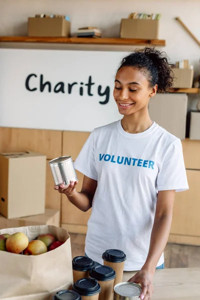 Bastante Afroamericano Voluntario Sosteniendo Estaño Mientras Está Pie Cerca Mesa — Foto de Stock