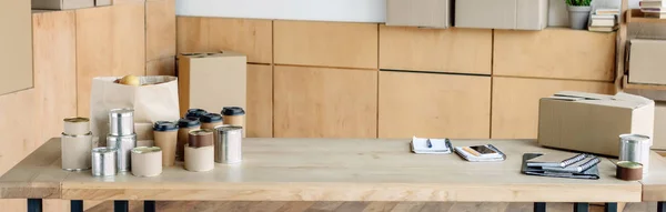 使い捨てカップ カートンボックス付き木製テーブルのパノラマショット — ストック写真