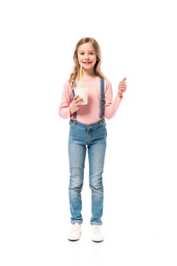 milkshake tutan gülümseyen çocuk tam uzunlukta görünümü ve beyaz izole başparmak gösteren
