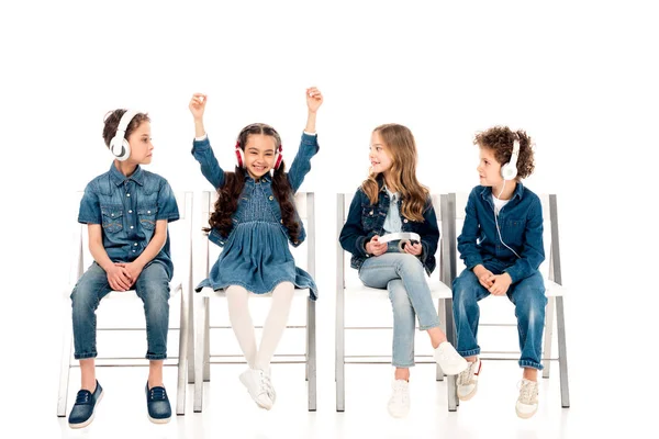 Four Kids Denim Clothes Sitting Chairs Listening Music Headphones White — Stock Photo, Image