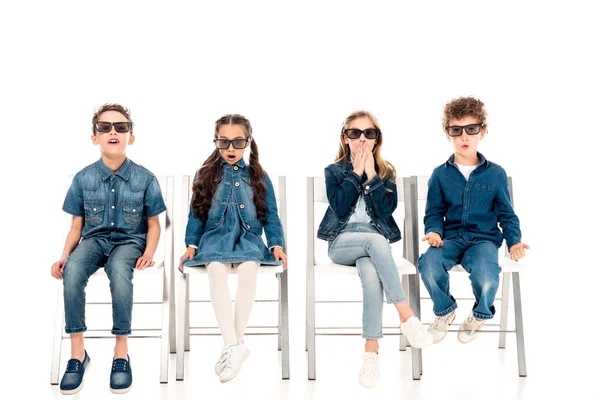 四个惊讶的孩子在3D眼镜坐在椅子上的白色 — 图库照片