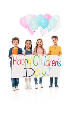 full length view of kids holding colorful balloons and placard on white clipart
