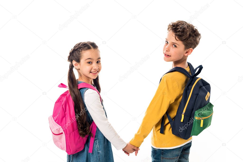 schoolchildren with backpacks holding hands and looking back isolated on white