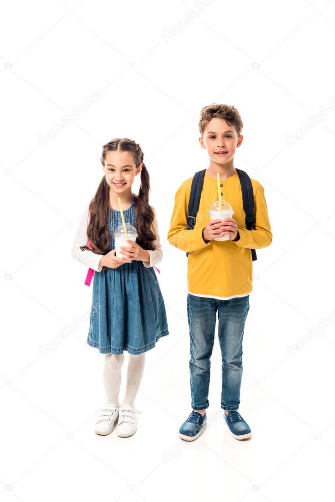 full length view of two kids holding milkshakes isolated on white