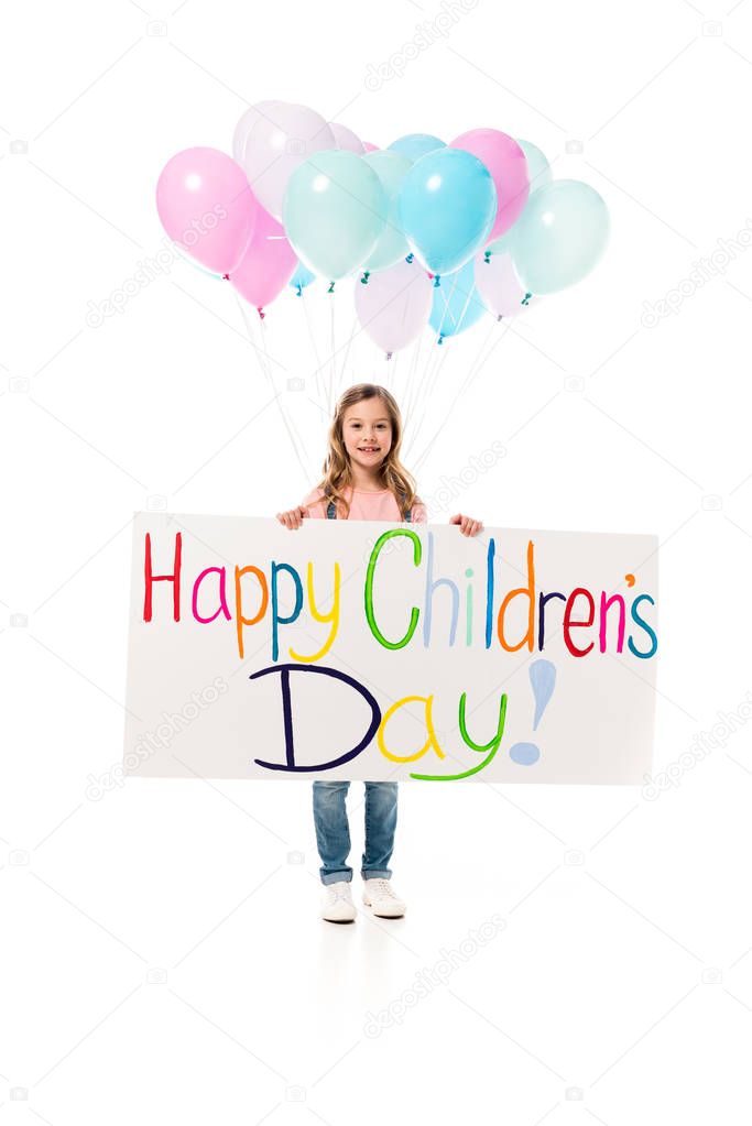 full length view of kid holding placard and balloons isolated on white