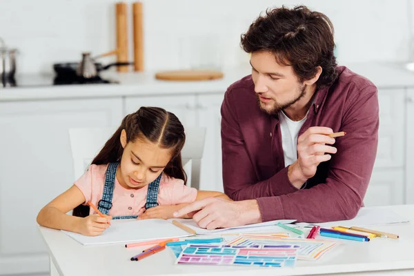 Guapo Padre Apuntando Con Dedo Papel Cerca Linda Hija — Foto de Stock