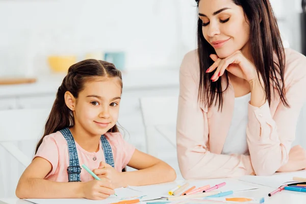 Happy Kid Tittar Kamera Nära Glada Brunett Mamma — Stockfoto