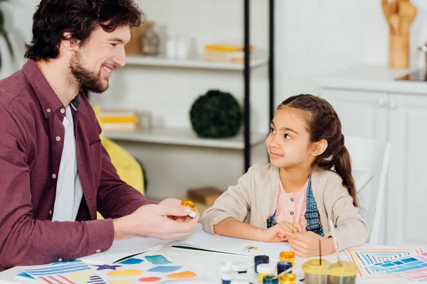 Alegre Padre Sosteniendo Gouache Tarro Cerca Feliz Hija Casa — Foto de Stock