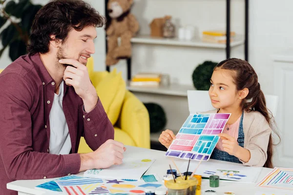 Lindo Niño Sosteniendo Papel Con Rayas Colores Cerca Feliz Padre — Foto de Stock