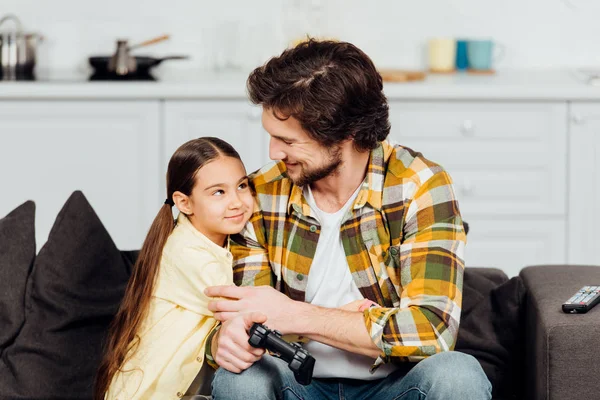 Happy Kid Hugging Cheerful Father Holding Joystick Home — Stock Photo, Image