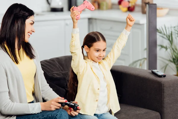 Happy Kid Gesturing Cheerful Mother Holding Joystick Home — Stock Photo, Image