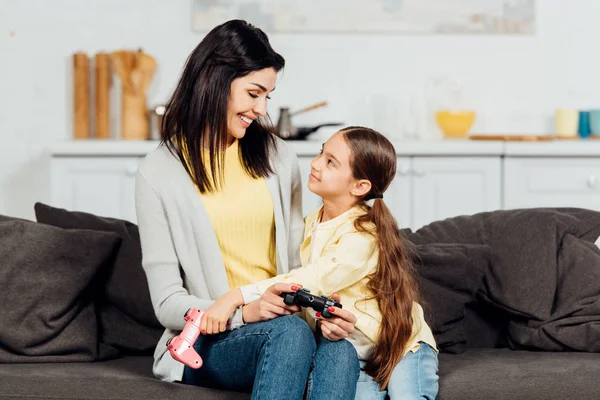 Criança Feliz Abraçando Mãe Alegre Segurando Joystick Casa — Fotografia de Stock