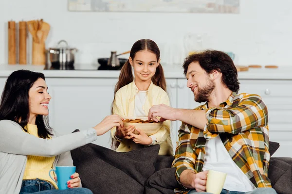 Happy Parents Taking Cookies Cute Daughter While Holding Cups — Stock Photo, Image