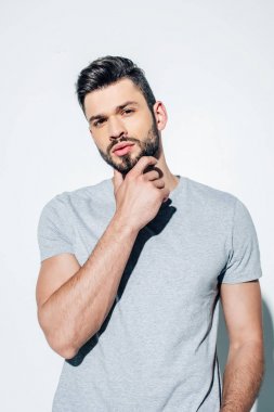 yakışıklı adam sakal dokunmadan ve beyaz kamera bakıyor 