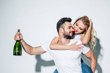 mutlu adam beyaz üzerinde piggybacking sarışın kız ise şampanya şişesi tutan 