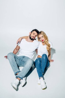 beyaz otururken kameraya bakarak çekici kız ve yakışıklı adam 