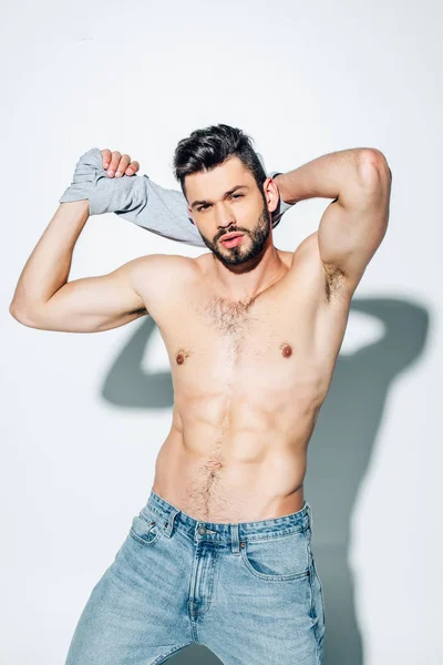 Hombre Guapo Musculoso Sosteniendo Camiseta Mientras Mira Cámara Blanco — Foto de Stock