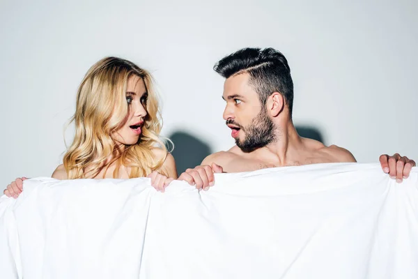 Mujer Rubia Sorprendida Hombre Guapo Mirándose Mientras Sostiene Manta Blanco — Foto de Stock