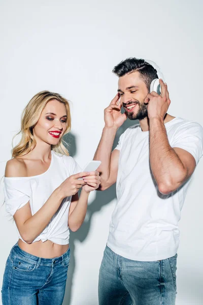 Cheerful Girl Holding Smartphone Bearded Man Headphones White — Stock Photo, Image