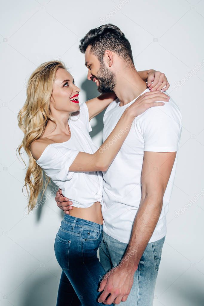 happy blonde woman hugging cheerful bearded man on white 