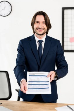 yakışıklı İşveren elinde özgeçmiş tutarken gülümseyen 