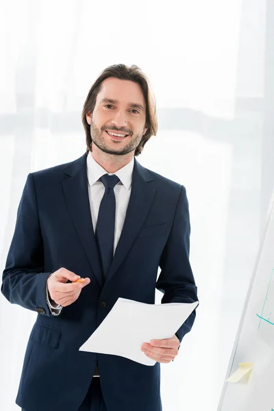 Hombre Guapo Sonriendo Mientras Sostiene Papel Lápiz Las Manos — Foto de Stock