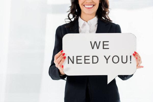 cropped view of cheerful recruiter holding speech bubble with we need you lettering 