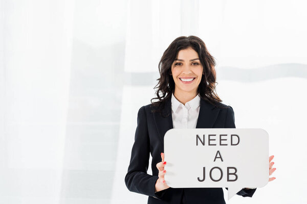 happy and beautiful employee holding speech bubble with need a job lettering 
