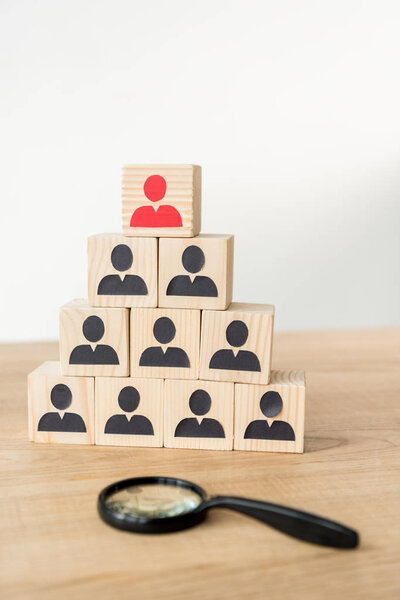 селективный фокус пирамиды иерархии управления рядом с увеличителем на белом
 