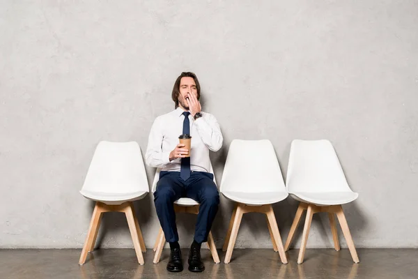 Tired Handsome Man Yawning While Holding Paper Cup Sitting Chair — Stock Photo, Image