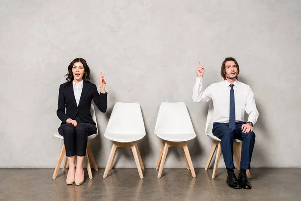 Gelukkig Brunette Vrouw Knappe Man Gebaren Terwijl Zittend Stoelen — Stockfoto