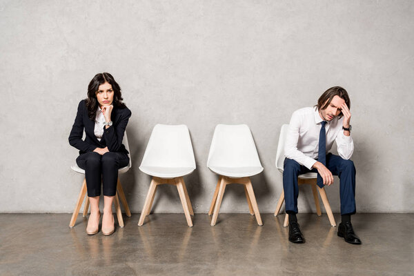 worried man sitting near attractive brunette woman on chair 