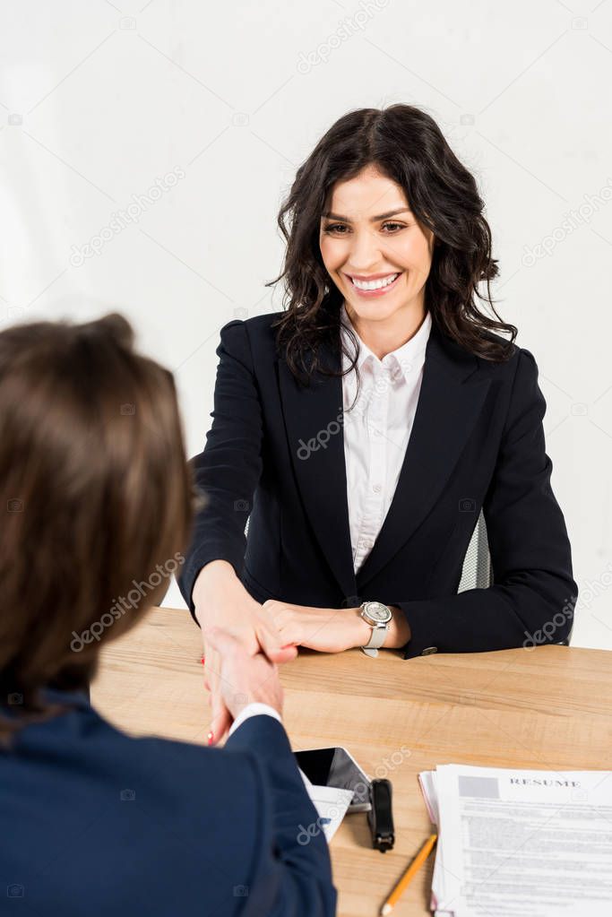 overhead view of beautiful woman shaking hands with recruiter in office 