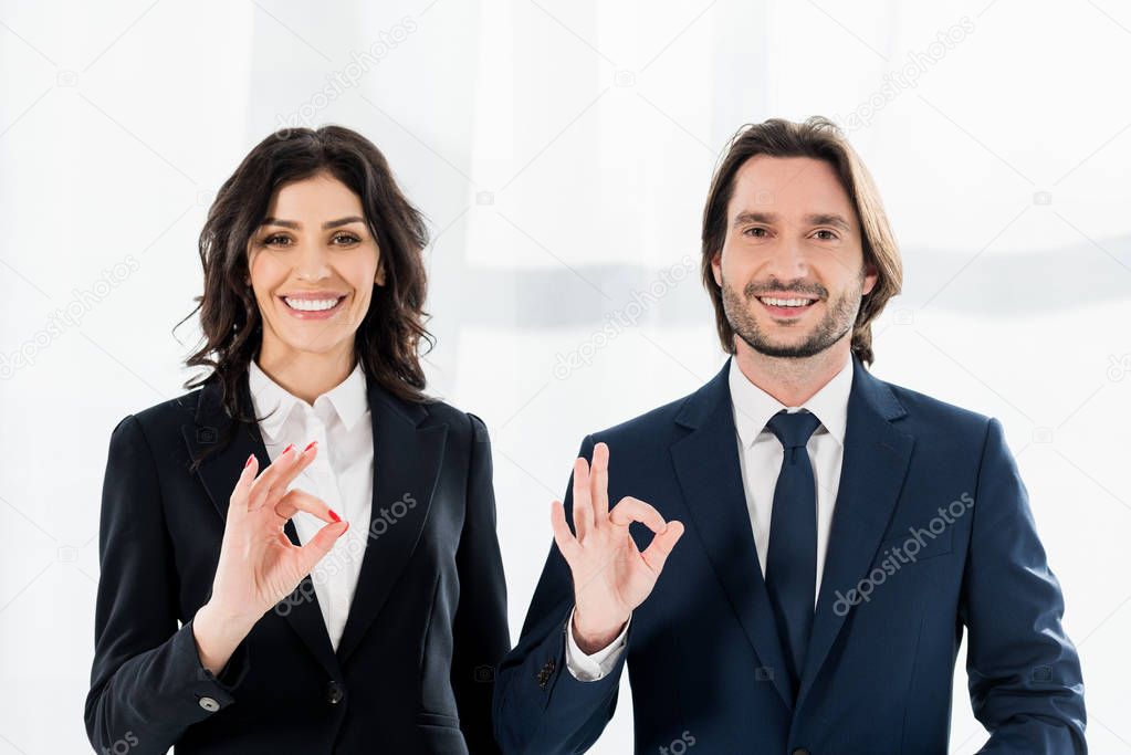 cheerful recruiters smiling while showing ok signs and looking at camera 