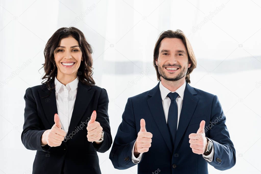 cheerful recruiters smiling while showing thumbs up and looking at camera 