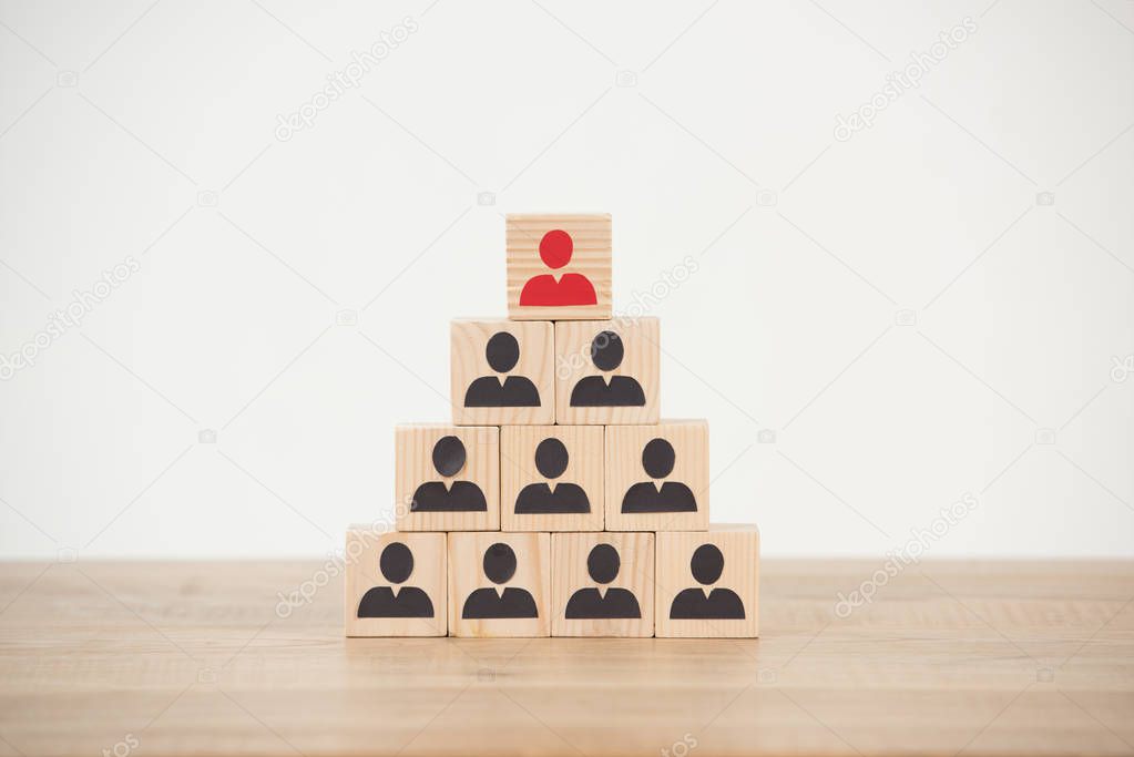 management hierarchy pyramid with wooden cubes on white