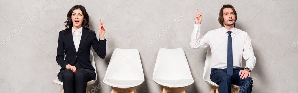 panoramic shot of happy brunette woman and handsome man gesturing while sitting on chairs 
