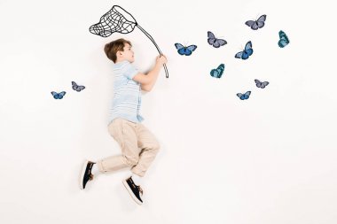 top view of cheerful kid holding butterfly net near butterflies on white  clipart