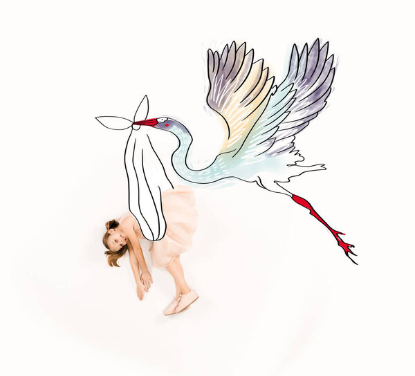 top view of stork carrying cheerful kid in pink dress on white 