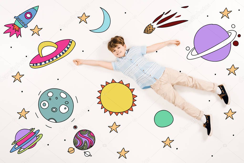 top view of cheerful kid flying in space on white 