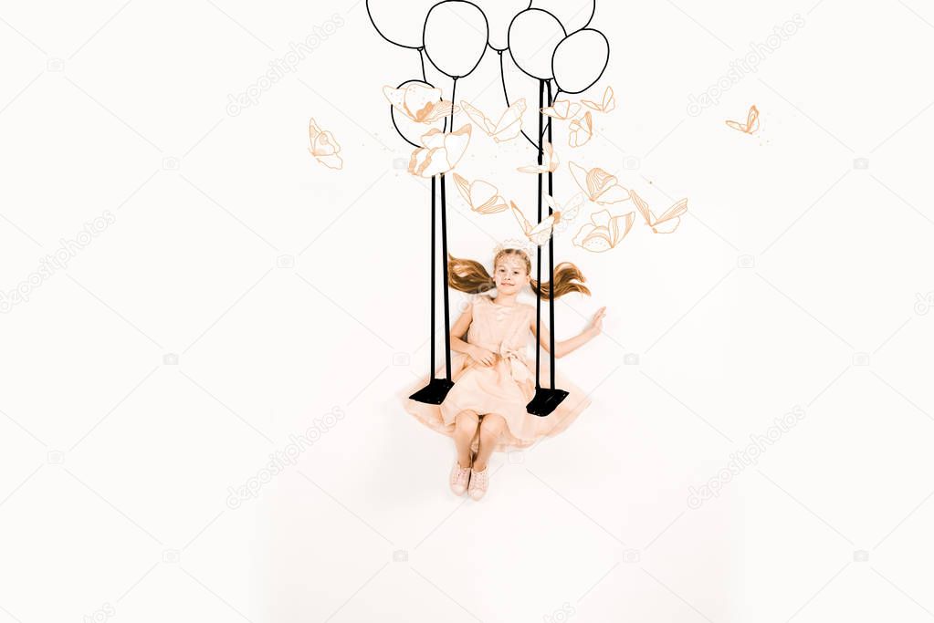 top view of cheerful kid in pink dress on swing near birds and balloons on white 