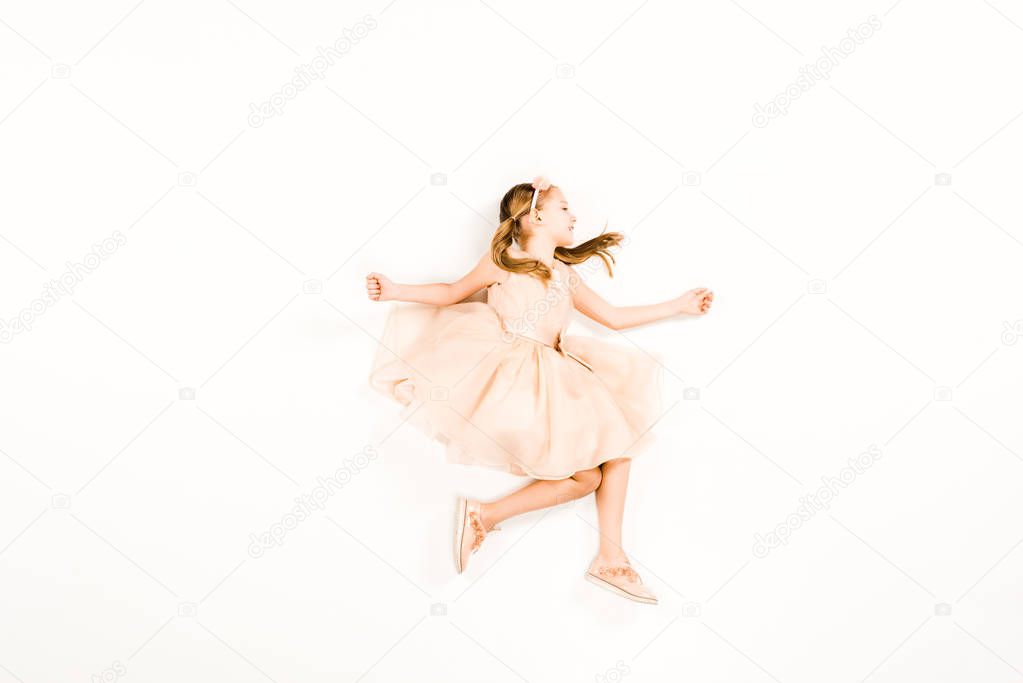 top view of cheerful kid in pink dress flying on white 