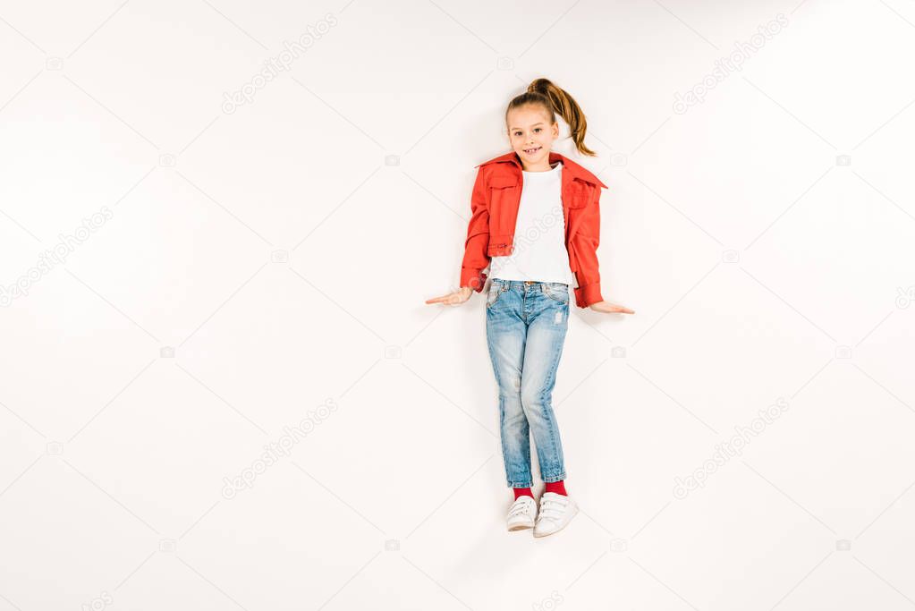 top view of happy child looking at camera and smiling on white 