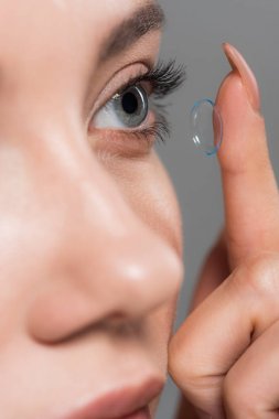 gri izole kontakt lens takarak genç kadının seçici odak 
