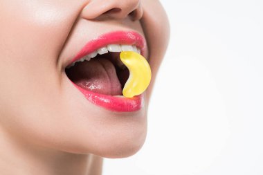 beyaz izole jöle şeker yiyen neşeli kız kırpılmış görünümü 