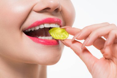 beyaz izole sarı jöle şeker yiyen neşeli kız kırpılmış görünümü 