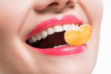 beyaz izole turuncu jöle şeker yiyen gülümseyen kız kırpılmış görünümü 