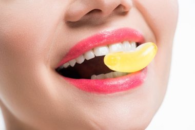 beyaz izole sarı jöle şeker yiyen gülümseyen kız kırpılmış görünümü 